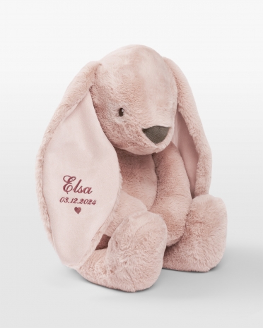 Stor kosekanin med rosa broderi av navn og fødselsdato.