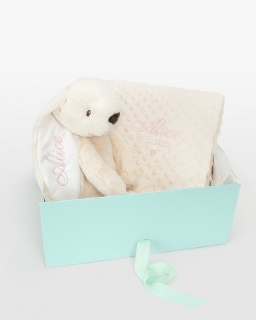 Gave-sett med kosedyr og babyteppe som broderes med navn.