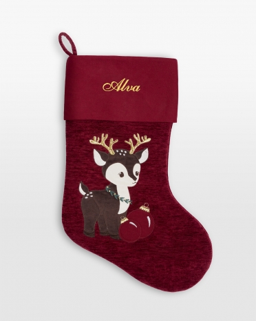 Rød julestrømpe i fløyel med brodert navn og et julinspirert motiv av et reinsdyr