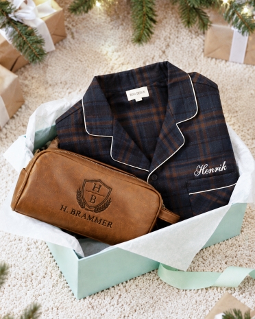 Julegavetips til ham med marineblå flanellpysj og cognacfarget toalettmappe brodert med valgfritt navn