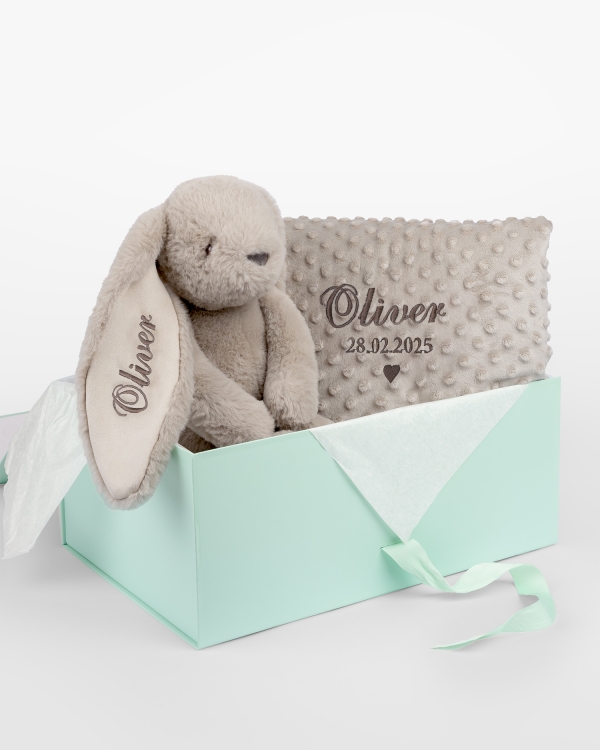 Gavesett med kosedyr og babyteppe som broderes med navn.