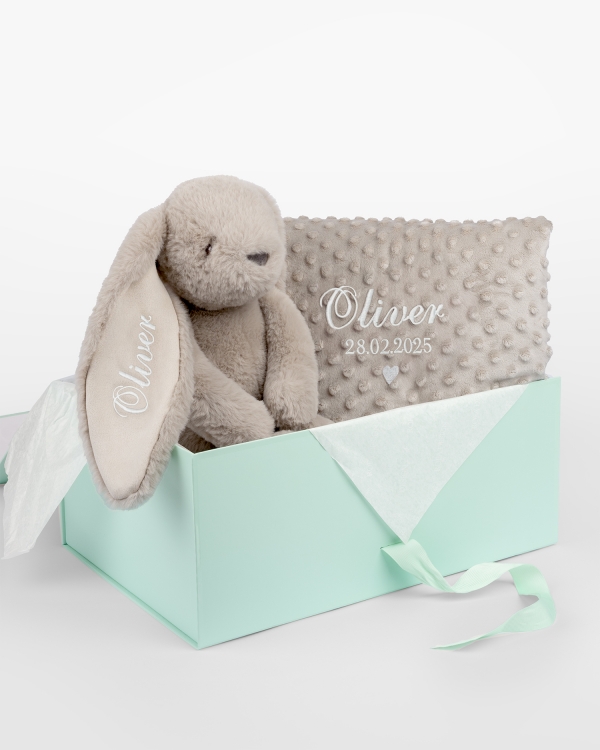 Gavesett med kosedyr og babyteppe som broderes med navn.