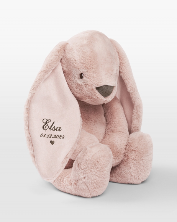 Stor kosekanin med brunt broderi av navn og fødselsdato.