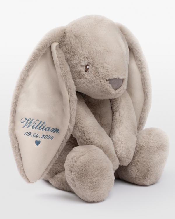 Sandfarget stor kosekanin med personlig blått broderi i øret.