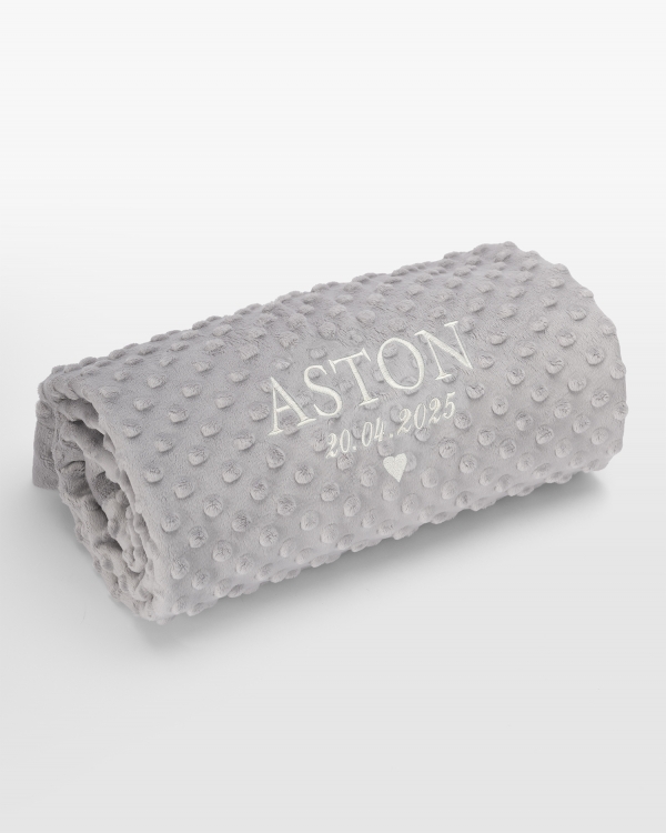 Grått teppe med hvitt navnebroderi