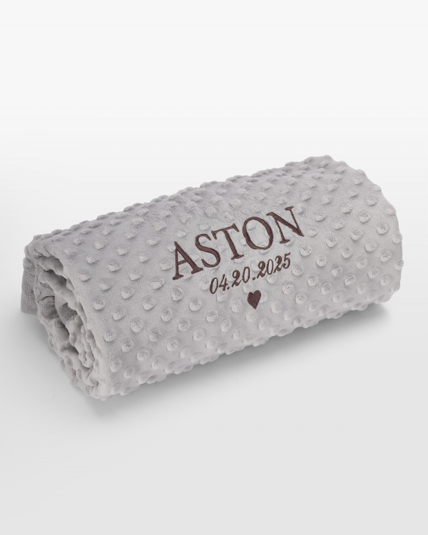 Grått babyteppe med navn i brun broderi