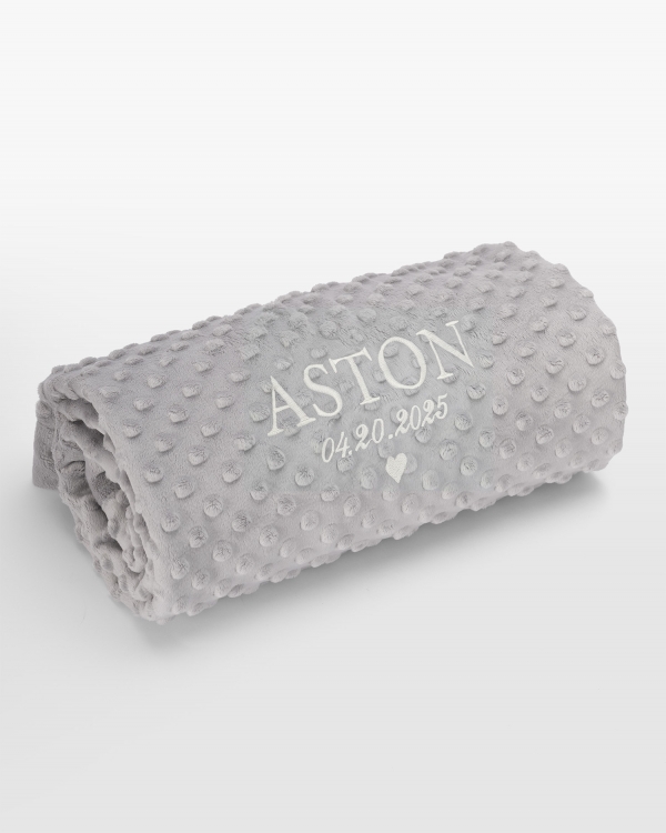 Grått teppe med hvitt navnebroderi