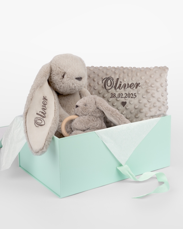 Gavesett med kosedyr og babyteppe som broderes med navn.
