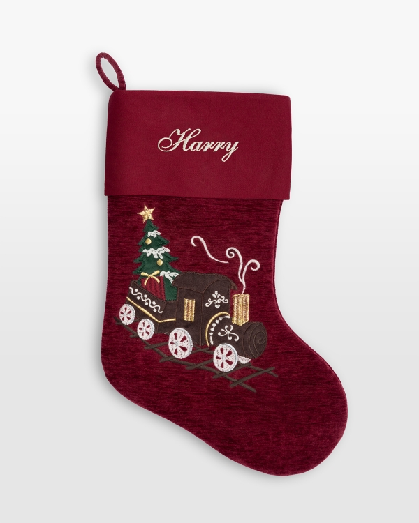 Rød julestrømpe med brodert navn og dekorativt togmotiv
