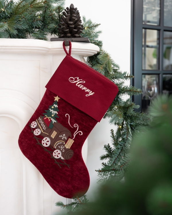 Rød julestrømpe med togmotiv og brodert navn