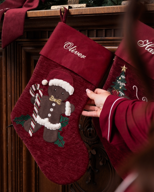 Rød julestrømpe med pepperkakemotiv og brodert navn