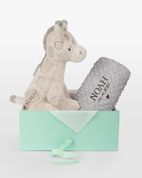 Kosedyr og grått teppe med brodert navn og dato