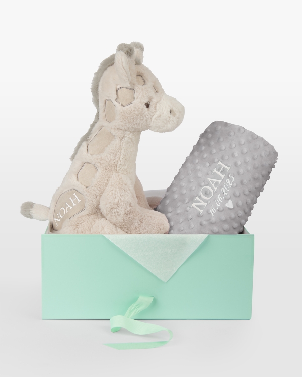 Kosedyr og grått teppe med brodert navn og dato