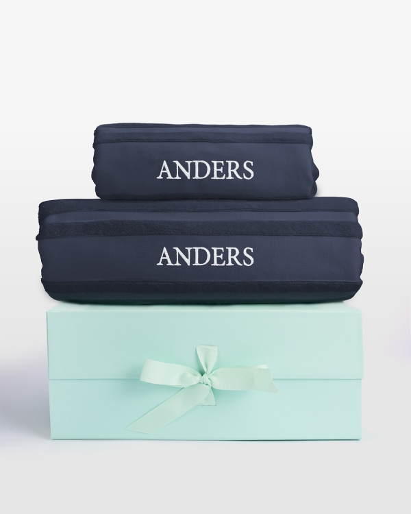 Marineblått håndklærsett med badehåndkle og hvit navnebrodert design, ideelt for luksuriøs stil og personlig komfort.
