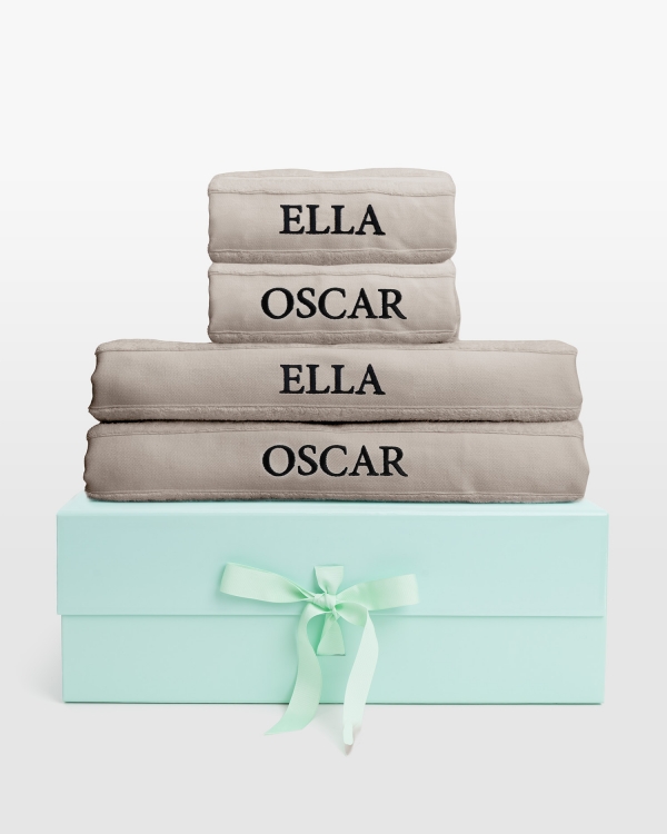 Sandfarget håndklærsett med badehåndklær og svart navnebrodert design, for tidløs stil og personlig komfort.