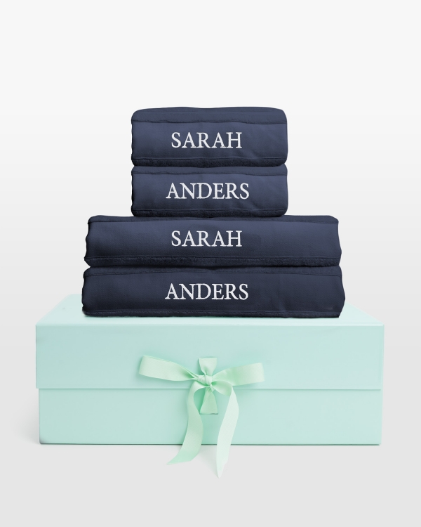 Marineblått håndklærsett med dusjhåndklær og hvit navnebrodert design, perfekt for stilfull komfort og personlig eleganse.
