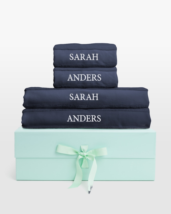 Marineblått håndklærsett med badehåndklær og hvit navnebrodert design, ideelt for luksuriøs stil og personlig komfort.