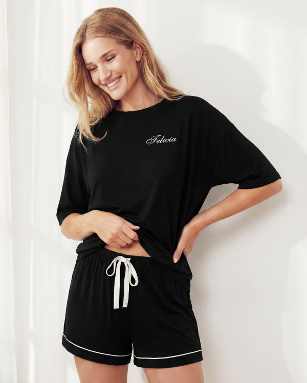 Svart pysjamassett med t-skjorte og shorts, hvite detaljer og personlig merking