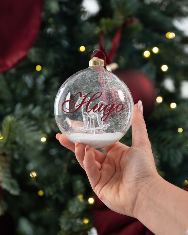 Julekule i glass med navn og motiv av en gyngehest
