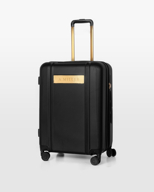 Svart koffert med navn og gulldetaljer