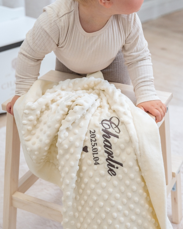 Cremefarget babyteppe med brodert navn og fødselsdato