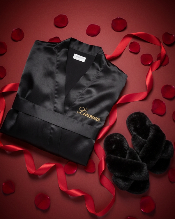 Fin valentinsdagsgave til henne med svarte, myke tøfler og svart satengbadekåpe med brodert navn i gull