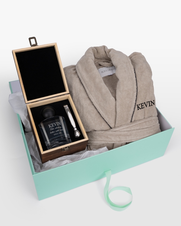 Sandfarget badekåpe med svart navnebrodert design og whiskyglass med gravert navn, perfekt for moderne eleganse og luksus.
