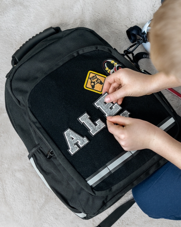 Svart skoleveske med tekstilmerker